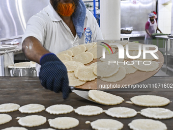 The vendor is preparing Qatayef, traditional pancakes that are popular during the Muslim fasting month of Ramadan, in Doha, Qatar, on March...