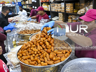 Vendors are selling traditional sweets to customers on the day of the Islamic holy month of Ramadan in Doha, Qatar, on March 12, 2024. (