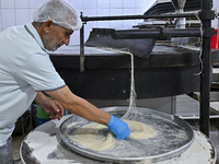 The vendor is preparing ''Kunafa,'' a traditional Arabic sweet, on the second day of fasting during the Muslim holy month of Ramadan in Doha...