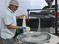 The vendor is preparing ''Kunafa,'' a traditional Arabic sweet, on the second day of fasting during the Muslim holy month of Ramadan in Doha...