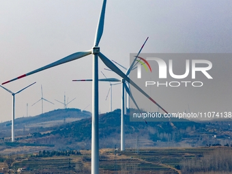 Giant windmills are spinning in the wind at Baoshan Town wind farm in the West Coast New Area of Qingdao, Shandong Province, China, on March...