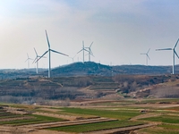 Giant windmills are spinning in the wind at Baoshan Town wind farm in the West Coast New Area of Qingdao, Shandong Province, China, on March...