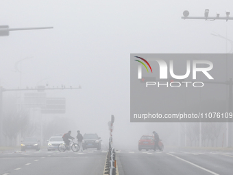 Citizens are traveling in thick fog in Huai'an, China, on March 15, 2024. (