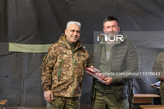 Major General Andrii Kovalchuk (L) is posing for a picture during the event to hand over mobile baths and restored trophy vehicles to the mi...
