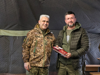 Major General Andrii Kovalchuk (L) is posing for a picture during the event to hand over mobile baths and restored trophy vehicles to the mi...