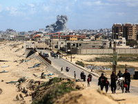 Smoke is rising following an Israeli strike while Palestinians are fleeing north Gaza to move southward, amid the ongoing conflict between I...