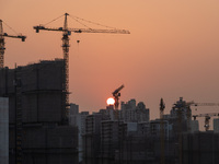 Residential buildings are under construction at sunset in Shanghai, China, on March 16, 2024. (