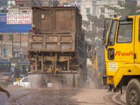A worker is spraying water from a truck to control dust in a polluted area in Dhaka, Bangladesh, on March 16, 2024. (