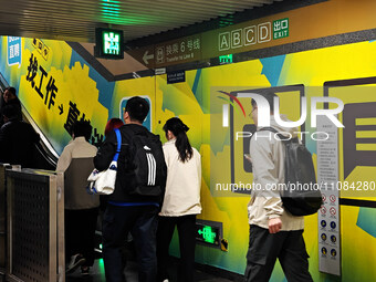 Passengers are walking past a light box advertising ''looking for jobs'' at Dawanglu Metro station in Beijing, China, on March 17, 2024. (