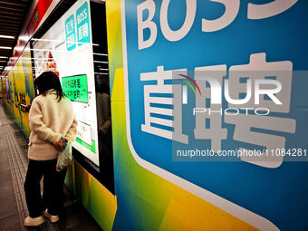 Passengers are walking past a light box advertising ''looking for jobs'' at Dawanglu Metro station in Beijing, China, on March 17, 2024. (