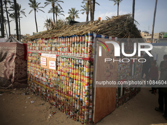 A group of young people are constructing a tent out of canned food cans to draw attention to the displaced Palestinians who have been forced...