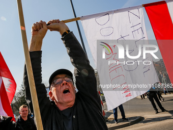A man holds a Polish flag  and a banner that says 'Green Deal to the Rubbish Bin' during a protest on Mogilskie roundabout in the centre of...