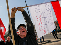 A man holds a Polish flag  and a banner that says 'Green Deal to the Rubbish Bin' during a protest on Mogilskie roundabout in the centre of...
