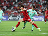 Li Yuanyi of China (R) is challenging Harhys Rizal Stewart of Singapore for the ball during the FIFA World Cup Asian 2nd qualifier match bet...