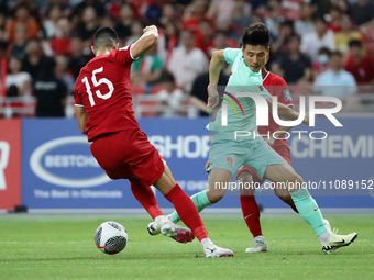 Lionel Tan of Singapore (L) is challenging Wu Lei of China for the ball during the FIFA World Cup Asian 2nd qualifier match between Singapor...