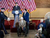 A Capitol Police officer assists Bernie Bluestein, a World War II veteran,  during a ceremony awarding the Congressional Gold Medal to the U...