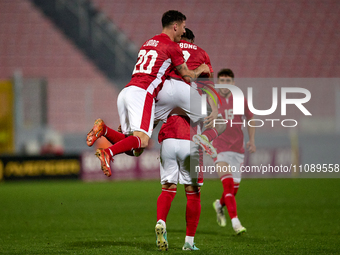 Matthew Guillaumier (center, mostly hidden) is being congratulated by Jean Borg (left) and Joseph Mbong (second from left) after scoring the...