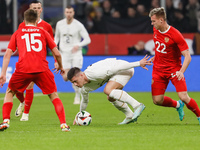 Luka Jovic (C) of Serbia in action against Danil Glebov (L) and Aleksandr Silyanov (R) of Russia during the international friendly match bet...