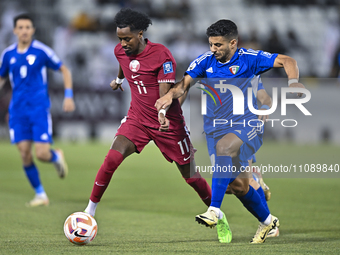 Yusuf Abdurisag (L) of Qatar is battling for the ball with Redha Abujabarah of Kuwait during the Qualification Round for the FIFA World Cup...