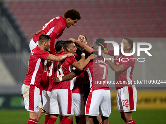 Players of the Malta national soccer team are celebrating their teammate Matthew Guillaimer's (hidden) equalizing goal, making the score 1-1...