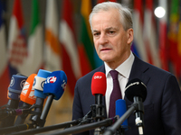 Norway's Prime Minister Jonas Gahr Store is speaking to the press as he arrives to attend the European Council summit on the second day in B...
