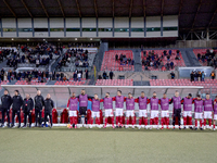 Coaches, technical staff, and substitute players of the Malta national soccer team are standing for their country's national anthem ahead of...