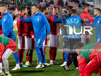 Players from the Malta and Slovenia national soccer teams are giving each other high-fives ahead of the friendly international soccer match...