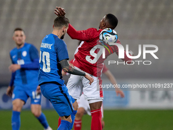 Petar Stojanovic of Slovenia is competing for the ball with Kemar Reid of Malta during the friendly international soccer match between Malta...