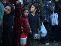 Displaced Palestinians are collecting food donated by a charity before an iftar meal, the breaking of the fast, on the twelfth day of the Mu...