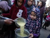 Displaced Palestinians are collecting food donated by a charity before an iftar meal, the breaking of the fast, on the twelfth day of the Mu...