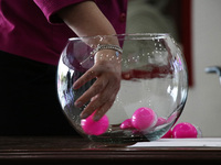 A hostess is mixing the electoral raffle balls during the Public Session of the Table of Representatives of the Presidential Debates, which...