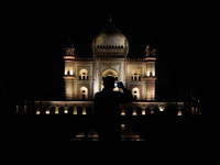 A media personnel is capturing an illuminated view of the Safdarjung Tomb before the Earth Hour environmental campaign in New Delhi, India,...