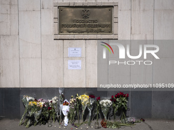 People are placing flowers outside the Russian embassy in Tehran, Iran, on March 24, 2024, to honor the victims of a shooting at the Crocus...