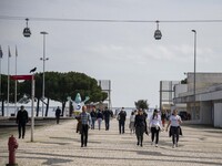 People are walking along one of the walkways in Das Nacoes Park in the Oriente section of Lisbon, Portugal, on March 13, 2024. (