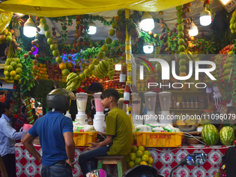 People are buying fruit juice for Iftar meals at a marketplace during the fasting month of Ramadan in Kolkata, India, on March 24, 2024. (