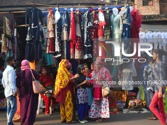 People are buying new dresses for the upcoming Eid al-Fitr festival at a marketplace during the fasting month of Ramadan in Kolkata, India,...