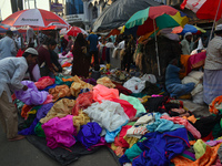 A person is selling colorful pieces of cloth for the upcoming Eid al-Fitr festival at a marketplace during the fasting month of Ramadan in K...