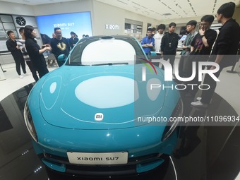 In Hangzhou, China, on March 25, 2024, citizens are looking at the Xiaomi SU7, the first mass-produced car by Xiaomi Motors, at a shopping m...