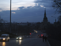 Cars are moving along a dark street in Kharkiv, Ukraine, on March 24, 2024, as the city is experiencing power outages following a Russian mi...