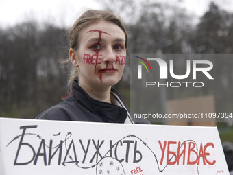 A demonstrator with her face painted is holding a placard during the ''Don't Keep Silent! Captivity Kills!'' action in support of Ukrainian...