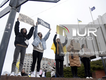 Demonstrators are holding placards outside the Ukrainian House National Centre during the ''Don't Keep Silent! Captivity Kills!'' action in...