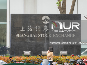 A citizen is walking past the Shanghai Stock Exchange in front of the Lujiazui Securities Building in Pudong, Shanghai, China, on March 25,...