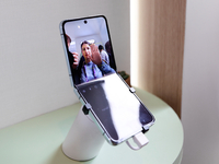 A woman is trying out the hands-free photoshoot mode of the Galaxy Z Flip5 in Barcelona, Spain, on March 25, 2024. The Samsung device, equip...