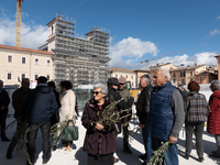 People bringing olive branches are seen in Piazza Duomo square in L’Aquila, Italy, on March 24th, 2024. Palm Sunday, observed on the Sunday...