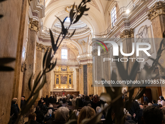 Olive branches and people attending a Holy Mass in Santa Maria del Suffragio church (also known as “Holy Souls Church”) are seen in L’Aquila...