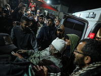 Palestinians are carrying injured victims to the hospital following an Israeli airstrike on a residential building in Al-Mughraqa, Central G...