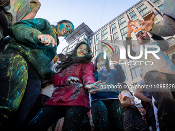 People dance to celebrate Holi, the Hindu holiday marking love and spring, in Washington, DC, March 25, 2024.   The holiday, often known as...