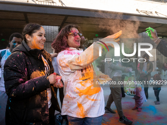 People throw colored powder on each other to celebrate Holi, the Hindu holiday marking love and spring, in Washington, DC, March 25, 2024....