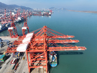 A cargo ship is stopping at a berth to load and unload containers at the container terminal in Lianyungang Port, in Lianyungang, China, on M...