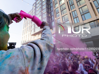 A man sprays the crowd with pink powder during a celebration of Holi, the Hindu holiday marking love and spring, in Washington, DC, March 25...